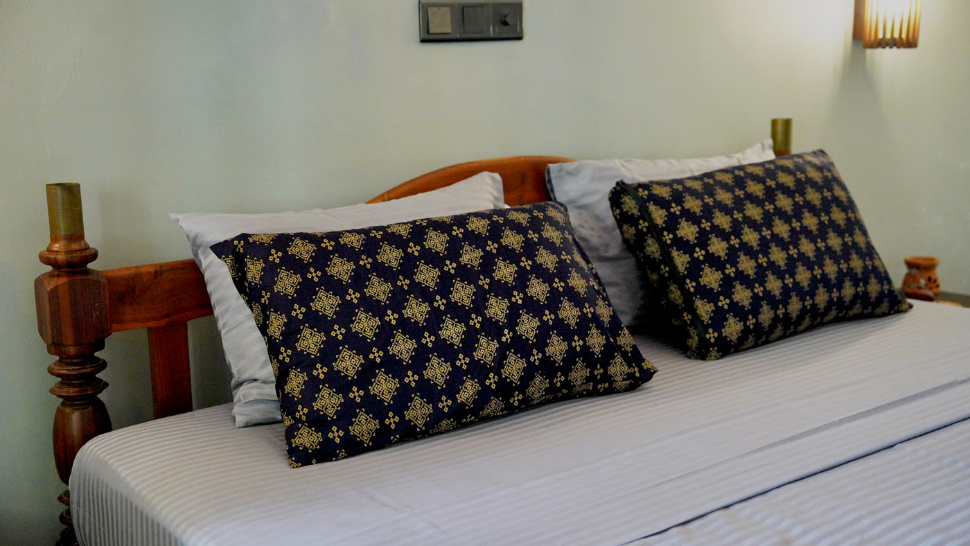 King bed with hand-blocked navy cushions at Breathe Collections