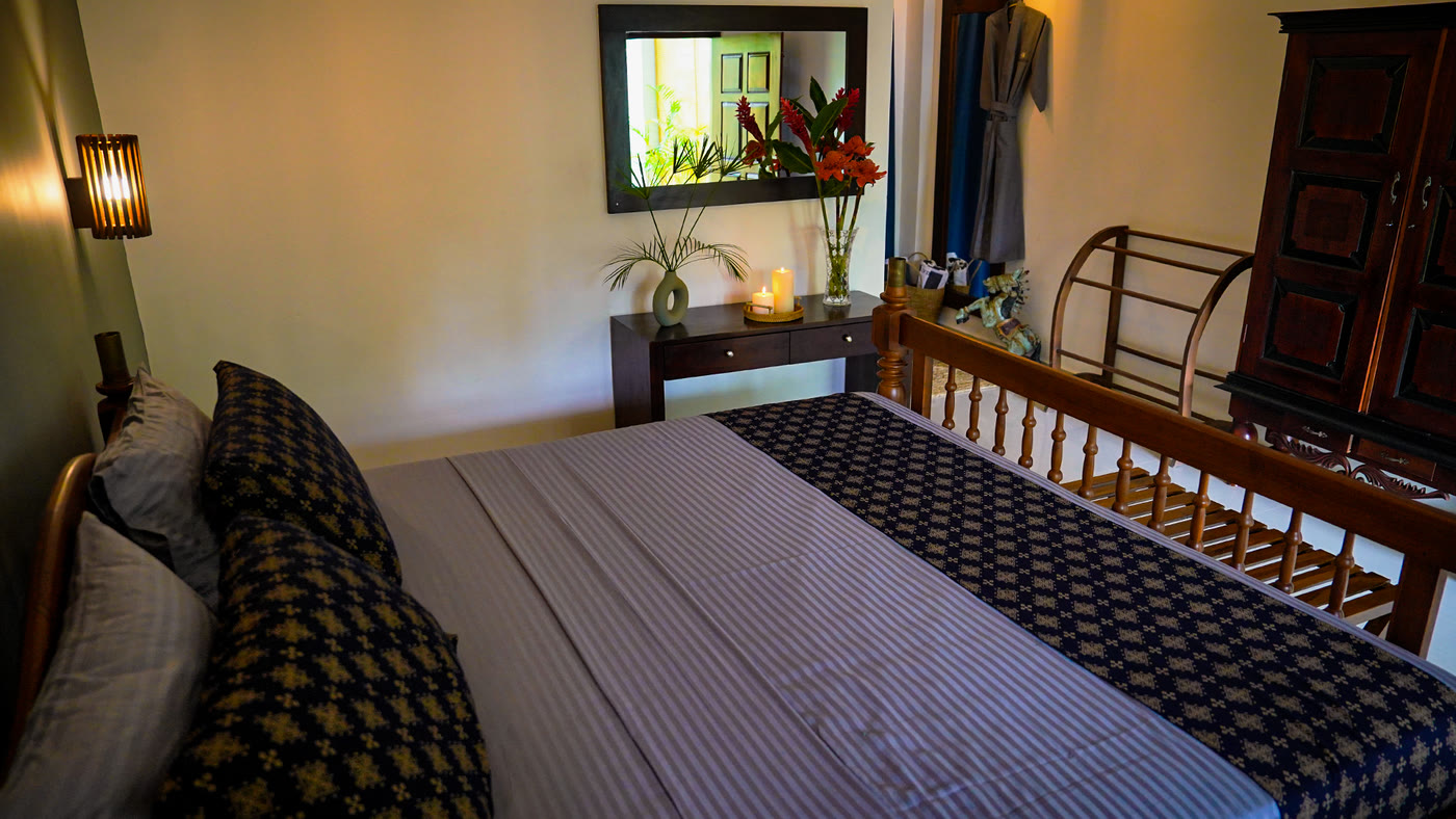 Guest room with antique mirror and four-poster bed, Habaraduwa Sri Lanka