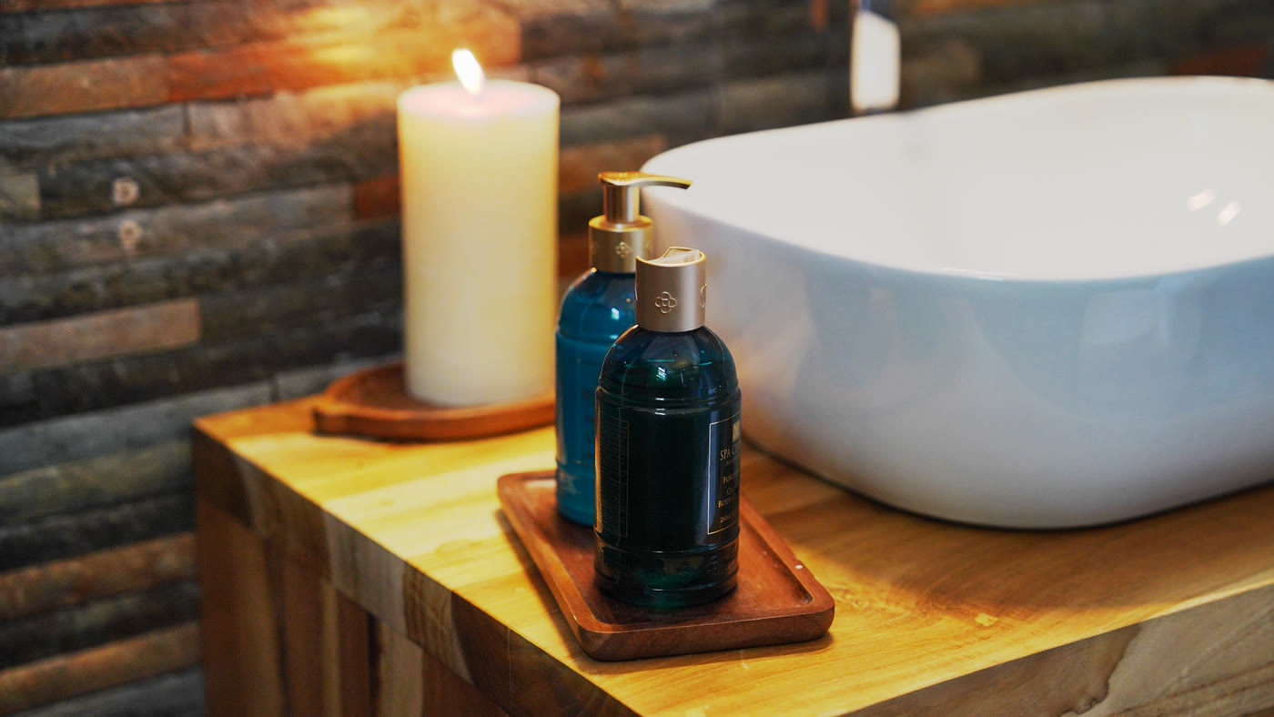 Bathroom washbasin with candle on teak counter, boutique hotel Sri Lanka